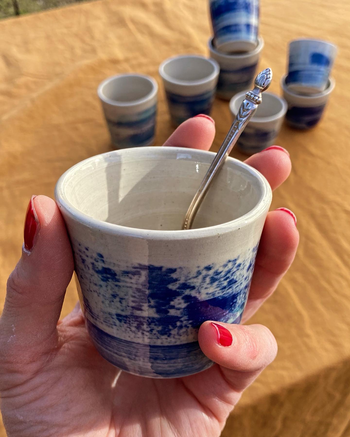 Tasse en porcelaine à décor indigo, tenue dans la main