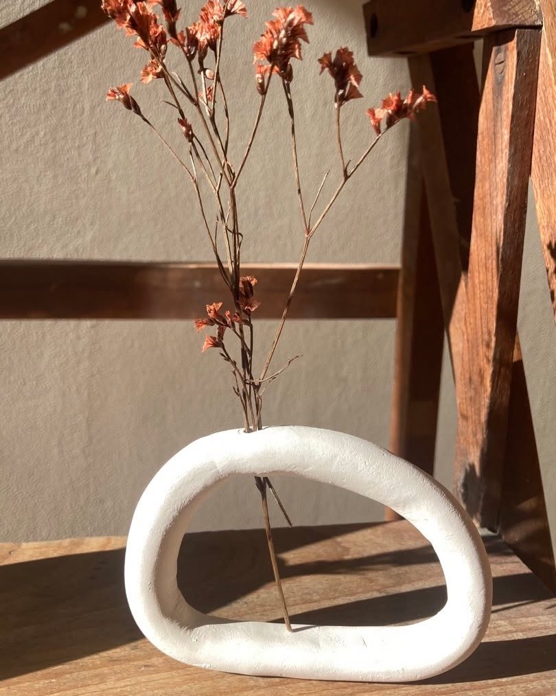 Vase anneau en faïence blanche avec fleurs séchées